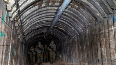 上周五，以色列士兵走过以军截至目前发现的一条由哈马斯设计的、可以容纳运载武装分子车辆以突袭边境的最大隧道。（图取自路透社）