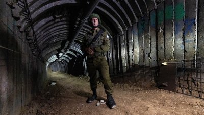 以色列军方发言人哈加里站在以色列军方指称哈马斯建造的，异常巨大的混凝土和铁围隧道里。（图：路透社）