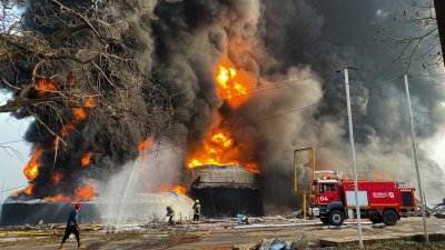 几内亚首都科纳克里大型油库周一凌晨发生爆炸后，消防员努力扑灭大火。（图取自路透社）