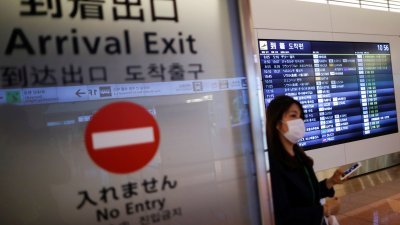 一名乘客走出东京羽田机场的抵达大厅。（图取自路透社）