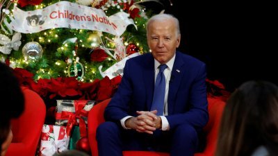 圣诞节将至，美国总统拜登周五在华盛顿的国家儿童医院，探望病人和家属。（图取自路透社）