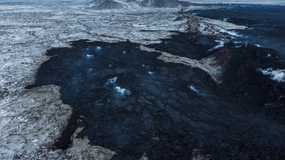冰岛的火山爆发活动平息，此前熔岩流经的大地，被烧成一片焦黑。（图取自路透社）
