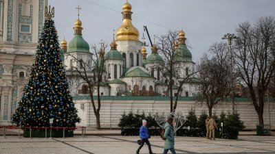 在乌克兰首都基辅，民众上周三在圣索菲亚大教堂前的圣诞树附近行走。（图取自路透社）