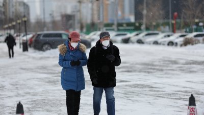 中国沈阳本月15日迎来降雪大风降温天气，当地市民穿著保暖衣物、戴著口罩在寒冷天气出行。（图取自中新社）
