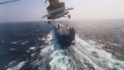 11月20日发布的照片显示，“青年运动”的直升机飞越在红海航行的“Galaxy Leader”号货船。（图取自“青年运动”媒体/路透社档案照）