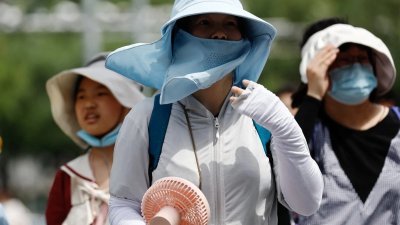 北京在今年夏天经历了历史性的高温。7月1日在北京街头可见，民众做好了防暑措施。（图取自路透社）
