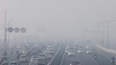 新德里周二出现浓雾，高速公路上的车辆在有限的能见度下行驶。（图取自路透社）