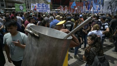 阿根廷民众背著空锅，在布宜诺斯艾利斯参加示威，抗议阿根廷新总统米莱的经济改革政策。（图取自法新社）