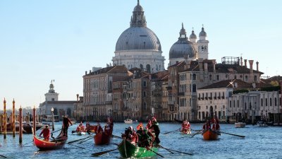 12月17日在意大利威尼斯大运河上，人们打扮成圣诞老人划船。（图取自路透社）