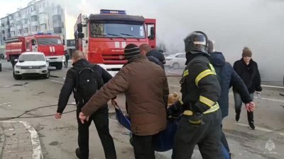 消防员和民众在别尔哥罗德市遭攻击后合力抬走受伤的人员。（图取自俄罗斯紧急情况部/法新社）