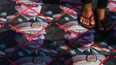缅甸军方2年前发动政变，引发大规模反政变示威。图为当年3月5日在仰光的示威中，民众将缅甸军政府领导人敏昂莱的照片踩在脚下，宣泄不满。（法新社档案照）