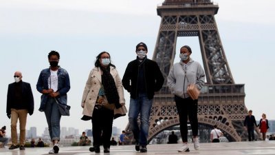 2020年5月16日，在巴黎埃菲尔铁塔附近戴著口罩的民众。（图取自路透社档案照）