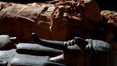 图为一具古埃及木乃伊摆在其棺墓旁。（图取自路透社）