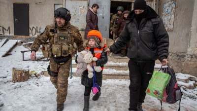 乌克兰警方替6岁女孩阿莉娜穿上儿童防弹背心和戴上亮橙色头盔后，他们在炮击声中撤离公寓楼，坐上一辆等候的面包车离开。（图取自路透社）