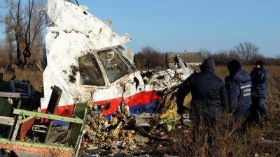 2014年11月20日，工人们在乌克兰东部顿涅茨克地区Hrabove（Grabovo）村附近的飞机失事现场，运送马航MH17航班的一块残骸。（图取自路透社档案照）