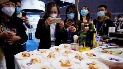 2020年11月6日在中国上海举行的第3届中国国际进口博览会 (CIIE) 期间，参观的民众在澳洲食品摊位拍摄澳洲龙虾制成美食的照片。（图取自路透社档案照）
