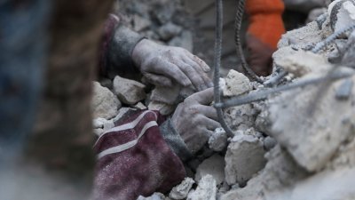 在叙利亚反抗军控制的金代里斯（Jindayris）镇，一名救援人员周三在一栋倒塌建筑的废墟下试图将一名男孩挖掘出来。（图取自法新社）