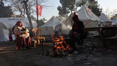 土耳其地震重灾区哈塔伊省的灾民，周五在避难营地的火堆旁取暖。（图取自路透社）