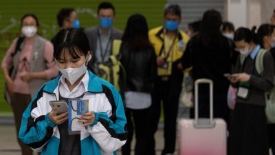中国和香港在2月6日全面恢复通关，戴著口罩的跨境学生在当天抵达罗湖管制站。（图取自路透社）