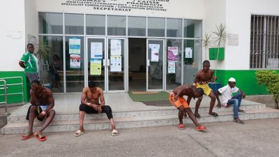 喀麦隆英语地区马拉松比赛爆炸案的伤者，在接受治疗后坐在医院前的阶梯上。（图取自法新社）