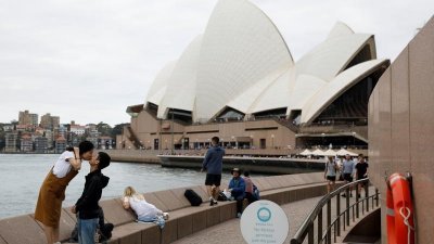 2018年4月18日，一对来自中国的游客在悉尼歌剧院前拍照。（图取自路透社档案照）
