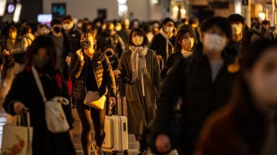 图为周四在东京羽田国际机场，大批民众抵达机场准备展开新年假期。（图取自法新社）