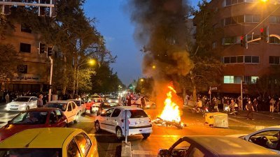 伊朗女子阿米尼之死点燃民众怒火，上街抗议百日至今仍未平息，据伊朗媒体表示，又有一名安全部队成员在抗议活动中遭枪杀。图为伊朗示威活动初期，民众在首都德黑兰燃烧摩托泄愤。（路透社档案照）
