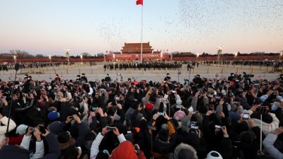 北京天安门广场在1月1日举行隆重的升国旗仪式，人们来到天安门广场观看升旗仪式，迎接新年。（图取自中新社）