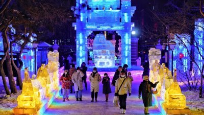 在黑龙江哈尔滨，民众周一晚游园赏冰灯。近日，第19届哈尔滨冰灯艺术游园会于哈尔滨兆麟公园内亮灯，民众在元旦假期前来观灯赏冰，感受冰灯魅力。（图取自中新社）