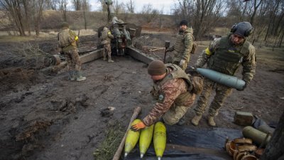 在乌克兰顿涅茨克地区，乌克兰军人周日在向俄罗斯军队阵地发射炮弹之前准备炮弹。（图取自路透社）
