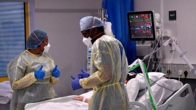 在英国米尔顿凯恩斯大学医院加护病房，护士们在监测一名新冠肺炎重症患者的情况。（图取自路透社档案照）