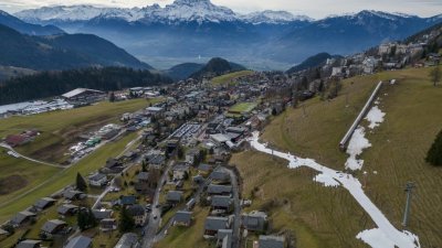 在瑞士莱森的阿尔卑斯山，滑雪者周三在比往常温暖的冬季下滑过一小层人造雪。（图取自路透社）