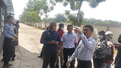 郑国霖（右2）巡视甘文丁Eco Medi手套厂，了解该厂的环境状况。