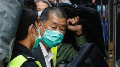 被控违反《港区国安法》的香港壹传媒集团创办人黎智英，去年2月在庭讯后登上巴士离开法院。（图取自路透社）