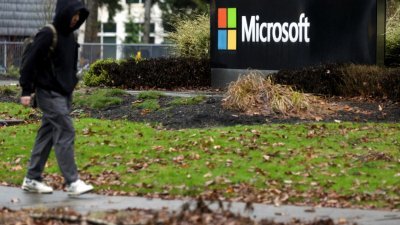 一名男子在周三走过总部位于美国华盛顿州雷德蒙德的微软标牌。（图取自路透社）