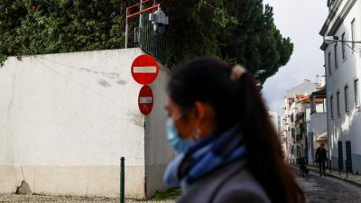 图为去年12月21日一名妇女经过中国驻里斯本大使馆外的闭路电视。（图取自路透社）