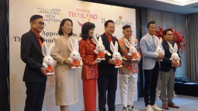 泰国国家旅游局局长育塔萨（中）与米雪（左3）、任达华（右2）等人手捧2023年“欢乐春节”吉祥物合影。（图取自中新社）