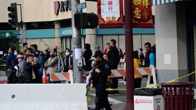 美国加州洛杉矶蒙特雷帕克市的当地居民，围聚在枪击案现场周围看警方查案。当地居民2/3属亚裔，其中绝大多数是华裔。（图取自法新社）