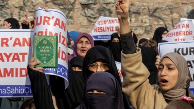抗议者周日在瑞典驻伊斯坦布尔总领事馆外高举《可兰经》，谴责丹麦极右翼政党党魁帕鲁丹焚烧《可兰经》。（图取自路透社）