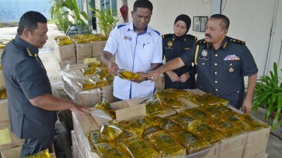 杰根（左2）及贸消局官员展示起获的一公斤装包装食用油。