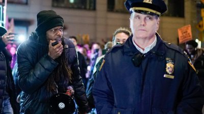 当地时间周六在纽约市华盛顿广场公园，一群民众发起集会示威，抗议非洲裔男子尼科尔斯遭警察暴力执法至死。一名示威者向一名纽约警察局官员高喊口号和脏话。（图取自法新社）


