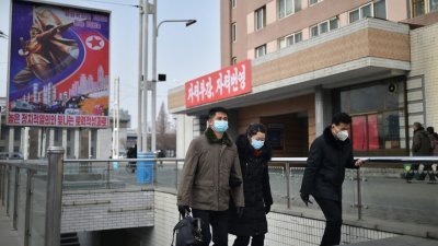 戴著口罩的朝鲜民众本月22日，走在首都平壤大街上。（图取自法新社）
