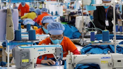 工人们在越南兴安省一家服装出口工厂工作。（图取自路透社）
