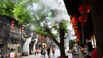 中国福州持续高温天气，南后街景区启动了水雾装置，给前来游玩的市民和游客消暑降温。（图取自中新社）