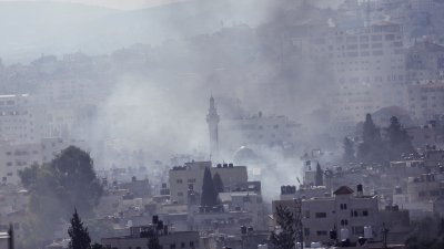 以色列周一在占领的约旦河西岸杰宁进行军事行动时冒出浓烟。（图取自路透社）