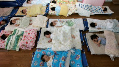 在日本西部守山市的Hinagiku托儿所里，一群孩子们正在午睡。（图取自路透社档案照）