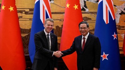 纽西兰总理希普金斯（左）和中国国务院总理李强，6月28日在中国北京人民大会堂举行的签字仪式上握手。（路透社档案照）