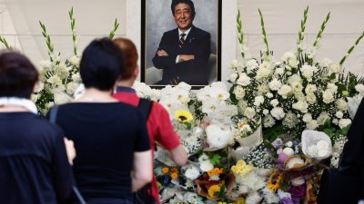 哀悼者周六在日本东京增上寺，向已故日本首相安倍晋三献花祈祷。（图取自路透社）
