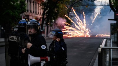 上周五，法国防暴警察在里昂的骚乱中与抗议者对峙，抗议者燃放烟花攻击警员。（图取自法新社）