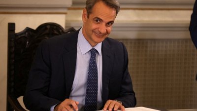 希腊总理米佐塔基斯于6月27日，在希腊雅典总统府举行的新任命政府成员宣誓就职仪式上签署文件。（路透社档案照）